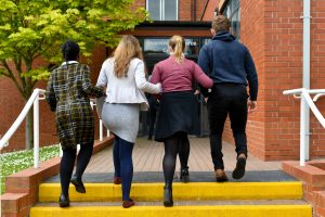 Four senior students walking arm in arm