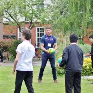 Students playing Hugby with Warriors player, Darren Barry