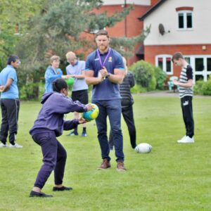 Students playing Hugby with Warriors player, Darren Barry