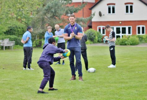 Students playing Hugby with Warriors player, Darren Barry