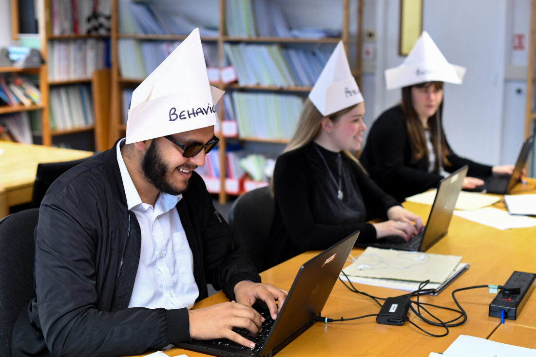image of students in a lesson wearing paper hats
