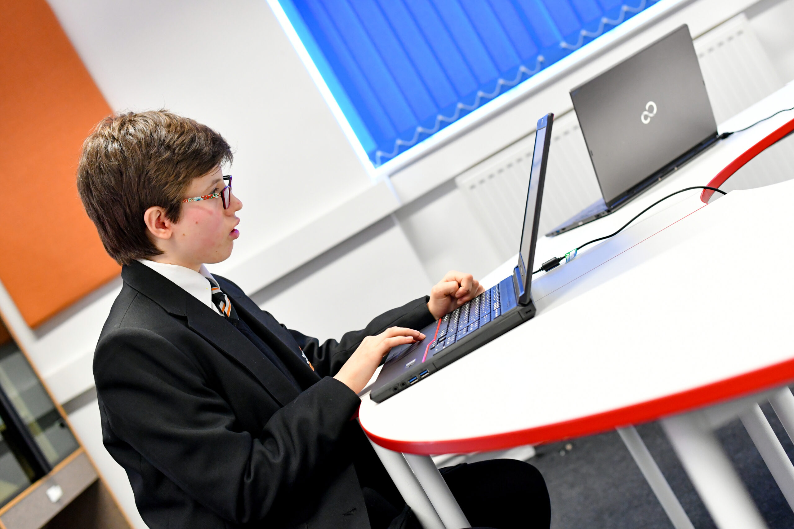 Female student sitting at a table using a laptop