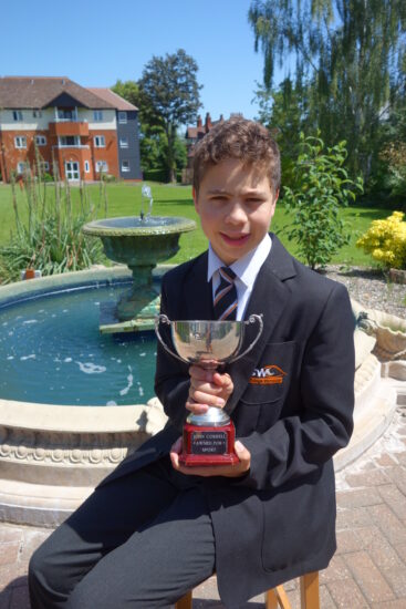 Student holding a silver cup in front of the Fountain