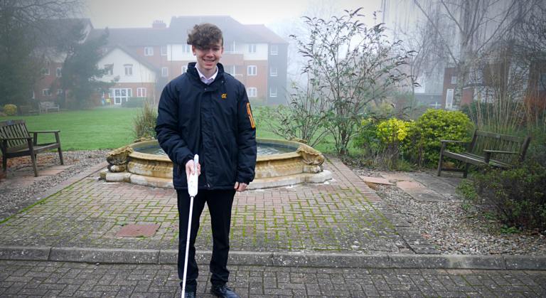 Student stood with interactive cane outside school