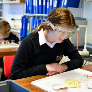 Student in Science lesson wearing protective eyewear and looking at different materials