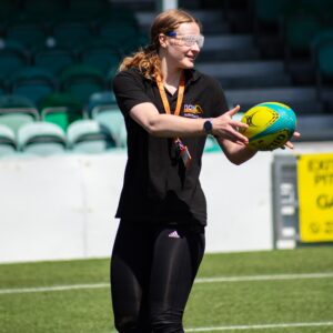 Megan from NCW Activities Team on the pitch catching the rugby ball - sim specs on