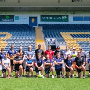 The whole group posing for a photo on the pitch