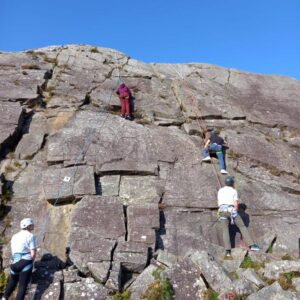 Mix of students rock climbing outdoors