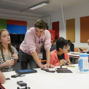 Adult male from Hable having a discussion with female VI student and other on the table about accessible technology