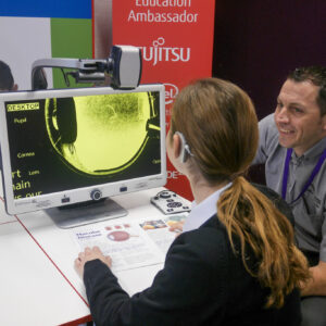 James from Optelec is showing female student how to use the DaVinci Pro machine