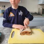 Student is cutting a sandwich in half