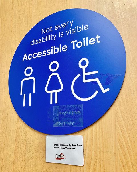 Image of the accessible toilet door sign with the braille stickers placed on it