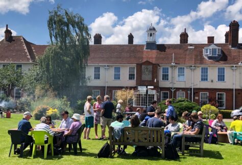 image of people enjoying a BBQ on the lawn outside NCW by the fountain