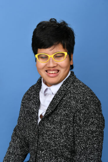 Rahel, head and shoulders shot wearing yellow framed spectacles