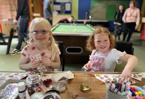 image of two children doing arts and crafts. they are smiling at the camera