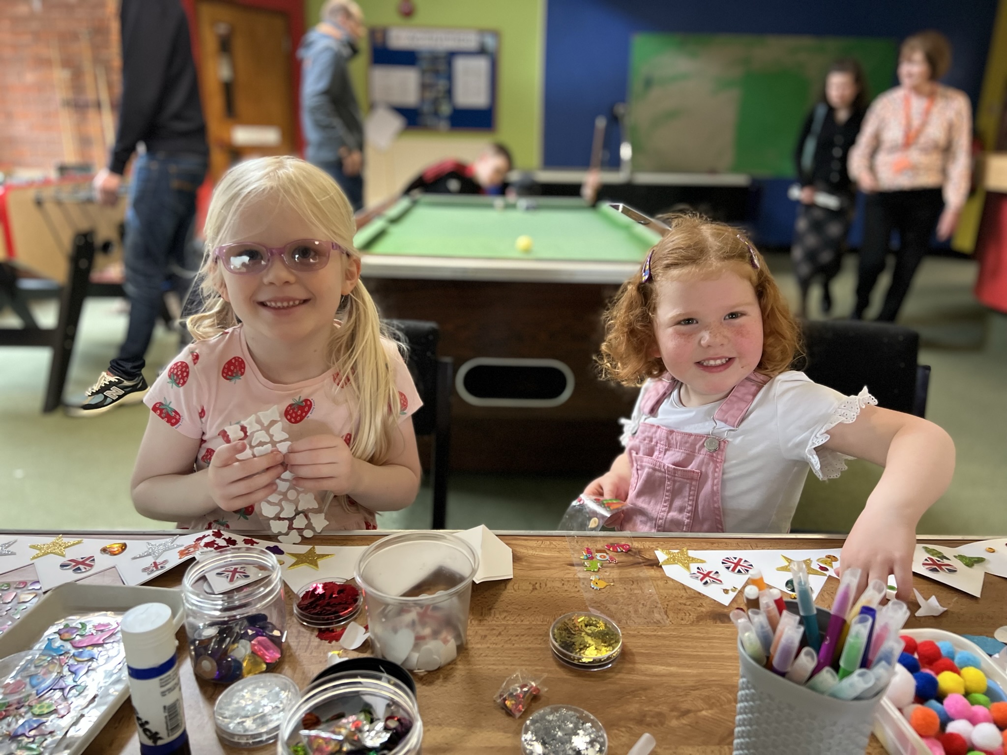 image of two children doing arts and crafts. they are smiling at the camera