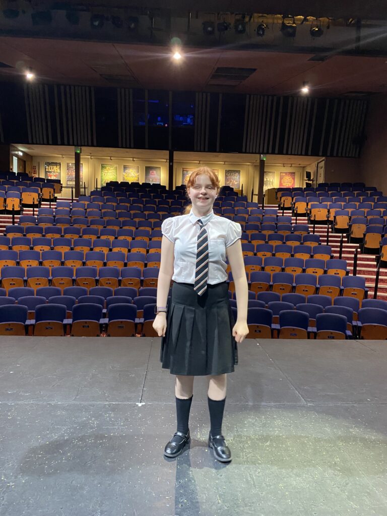 Image of Natalie standing on the stage of the Swan theatre smiling