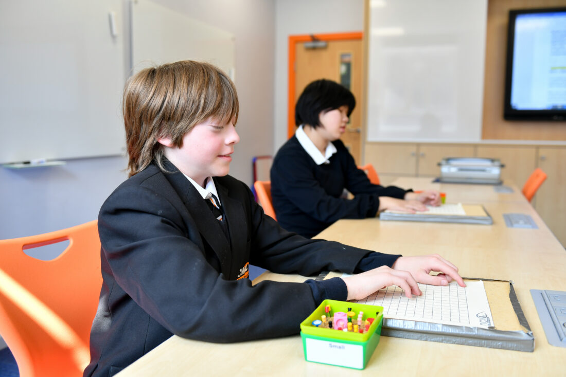 image of two students in a maths lesson using a tactile diagram with pins