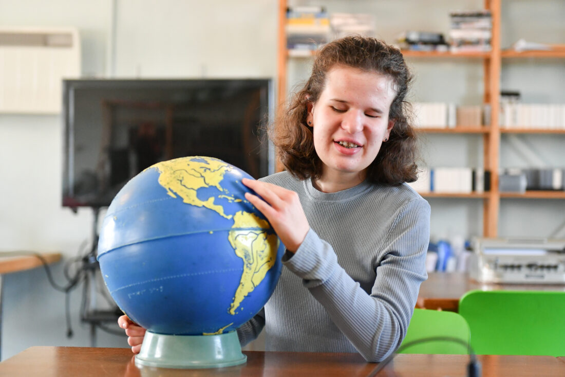 image of a student exploring a tactile globe