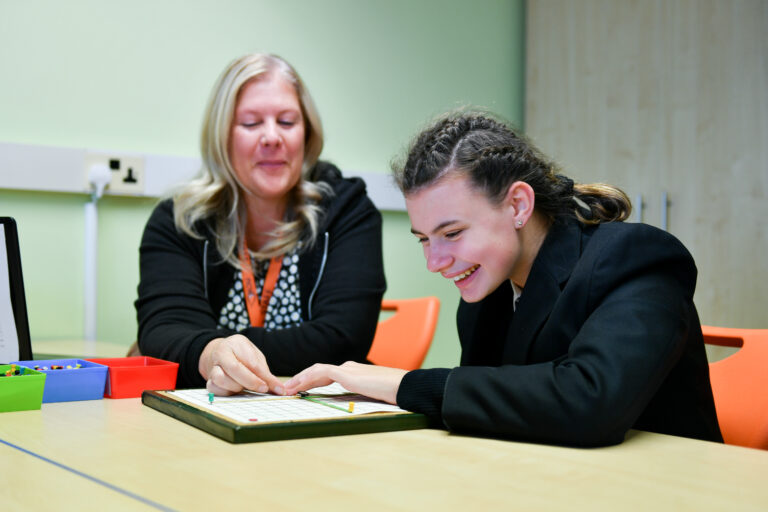 photo of a student and LSA working together in a maths lesson