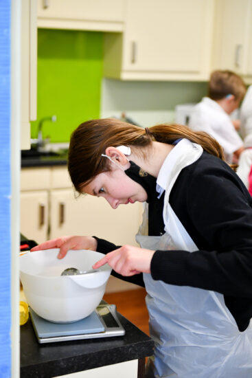 image of a student in an ILS lesson adding ingredients to a bowl