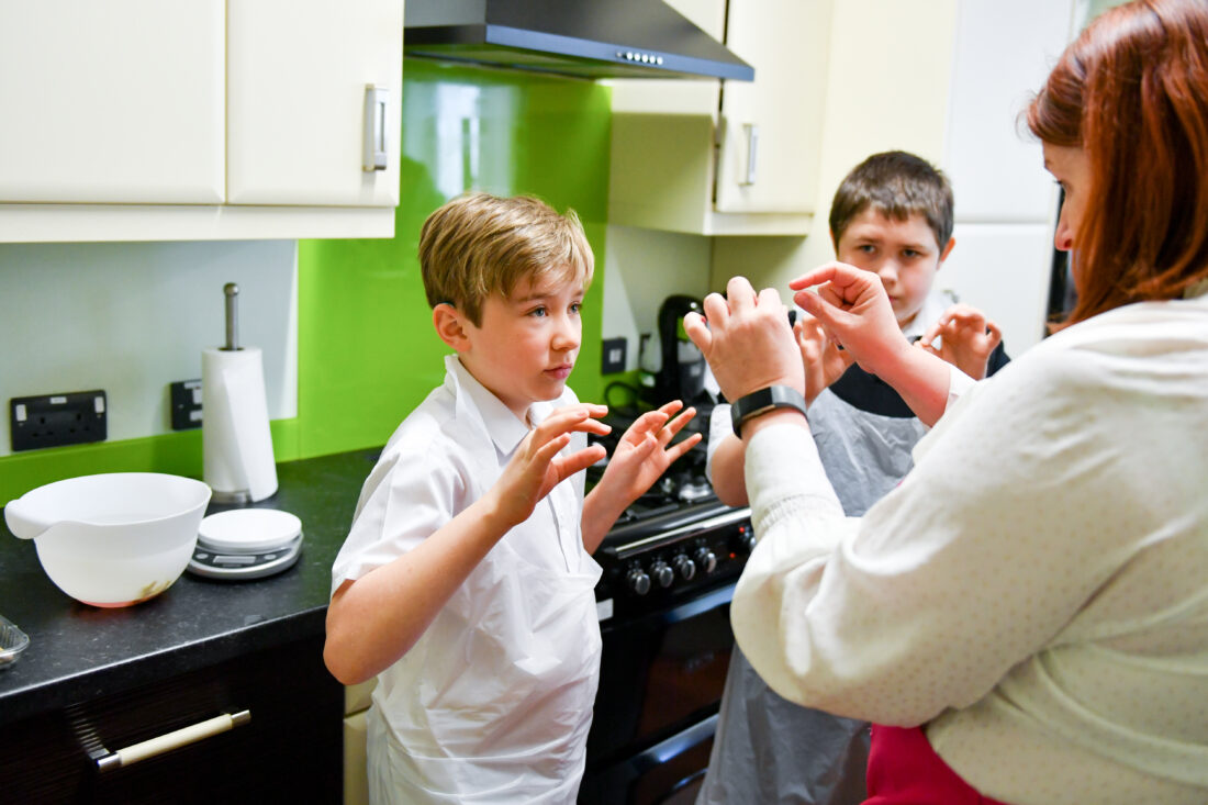 image of a student listening to a teacher during a cookery lesson