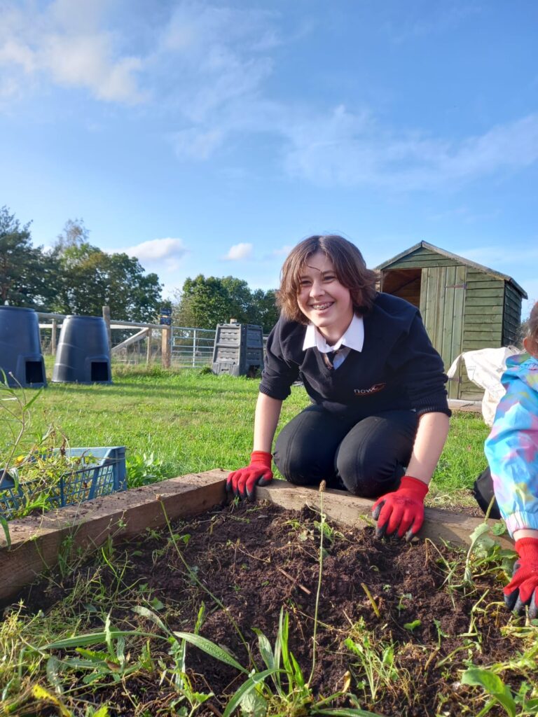 image of a student digging in a raised bed.
