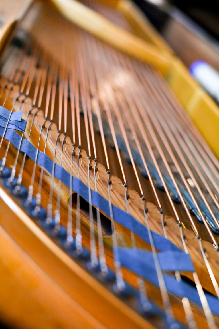 close up image of the inside of the piano and the strings