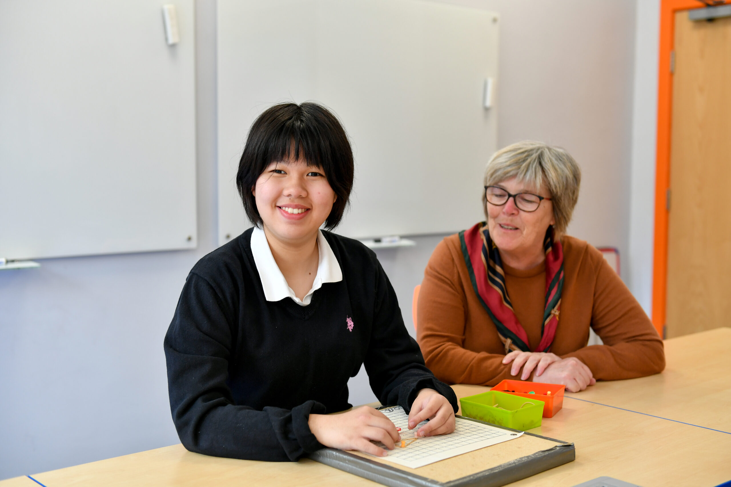 image of an international student smiling at the camera in a maths lesson