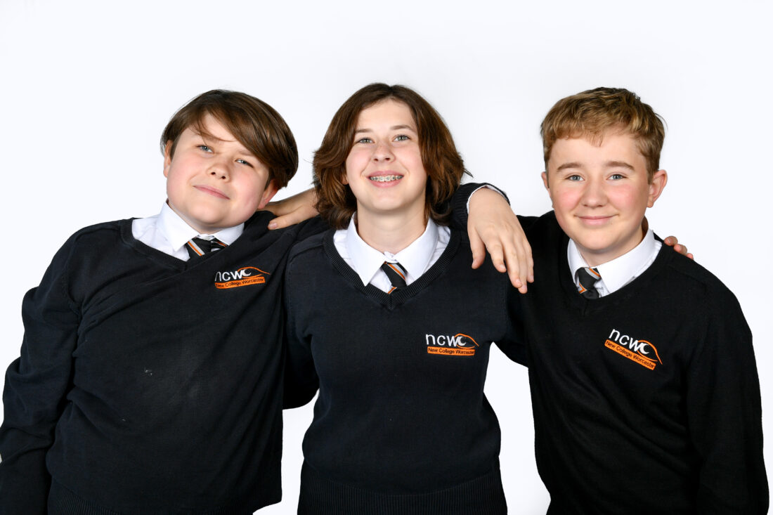 image of three students smiling at the camera with their arms linked around each others shoulders