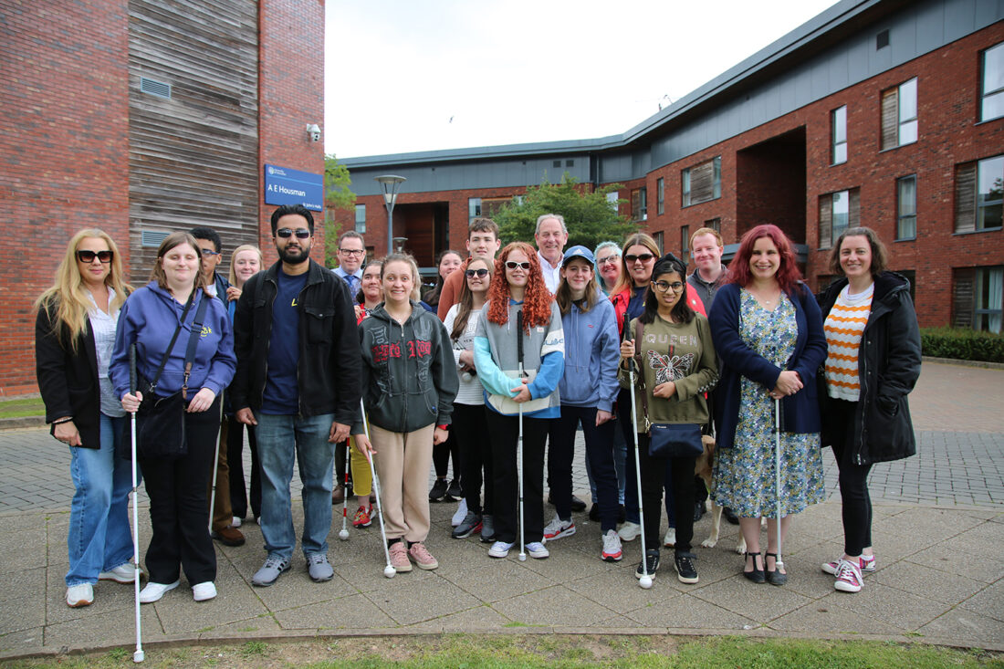 group photo of staff and students from various colleges outside the university