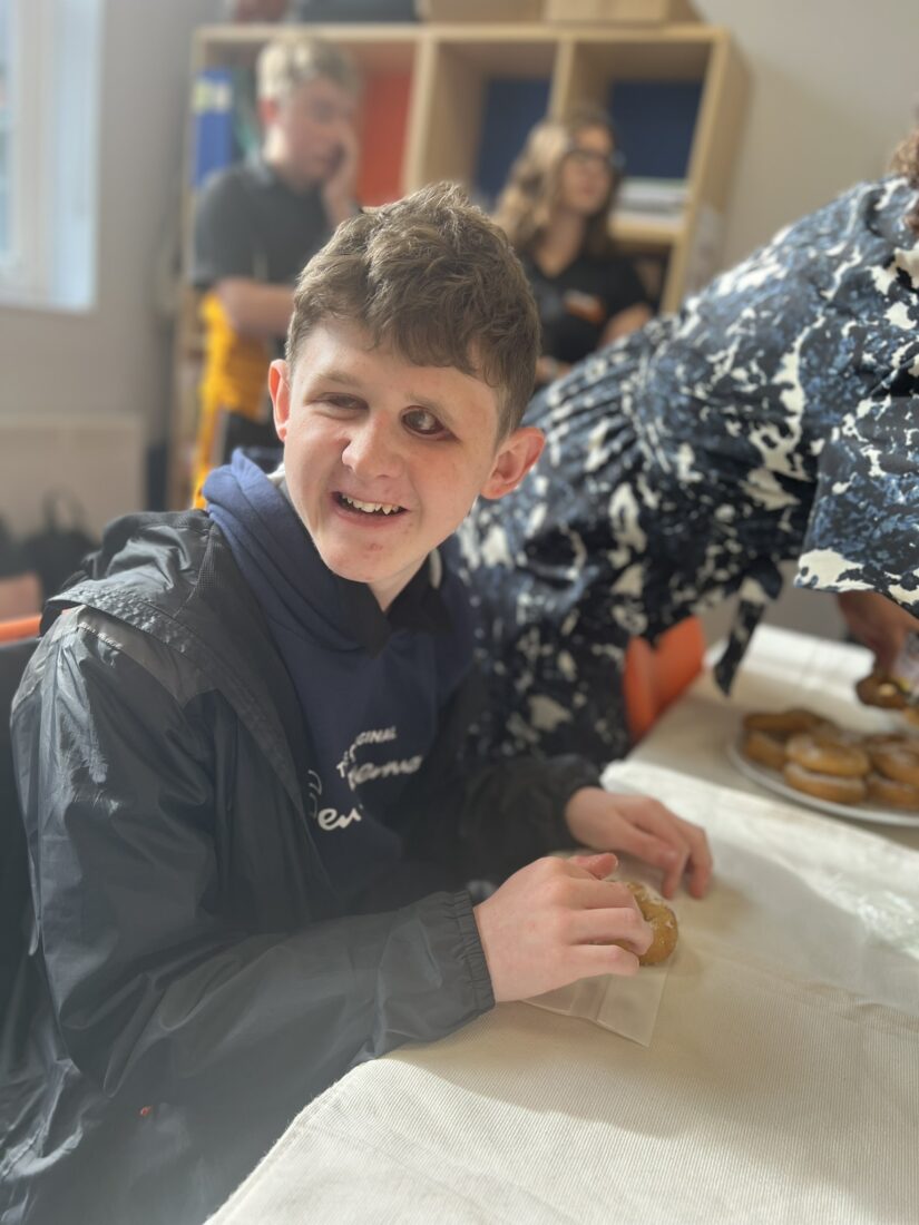image of a student smiling whist sat a table