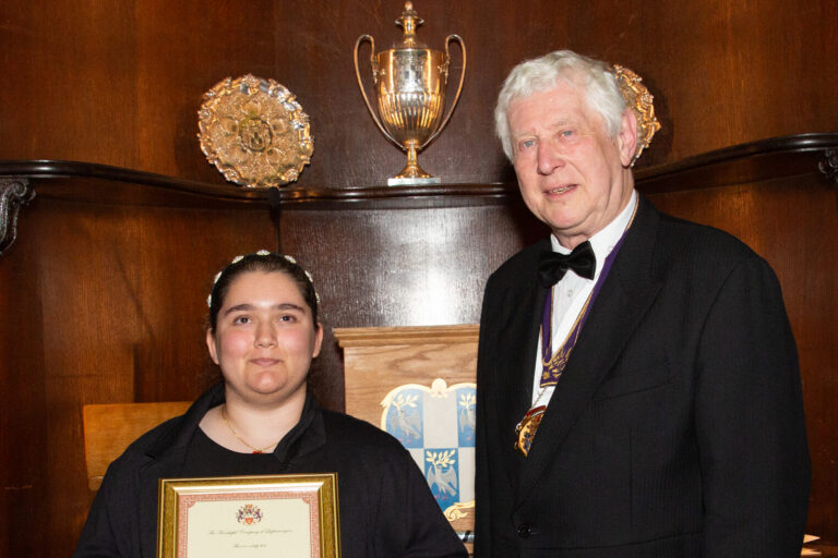 Photo of Asal holding a framed certificate with a Master