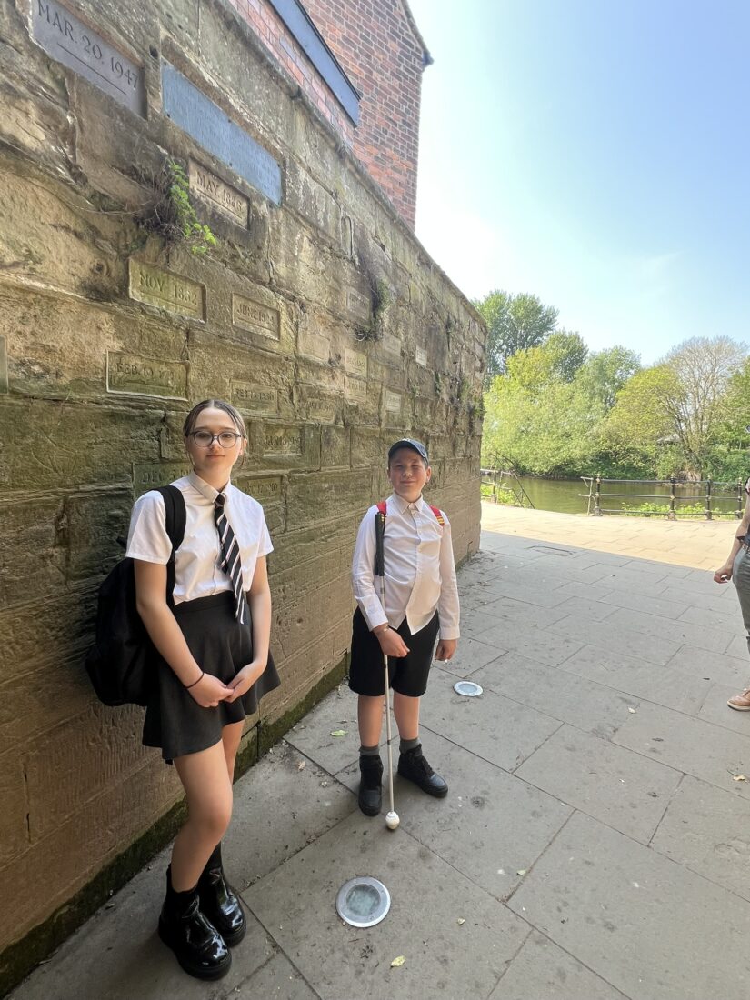 Photo of the students stood at the city walls exploring the flood lines