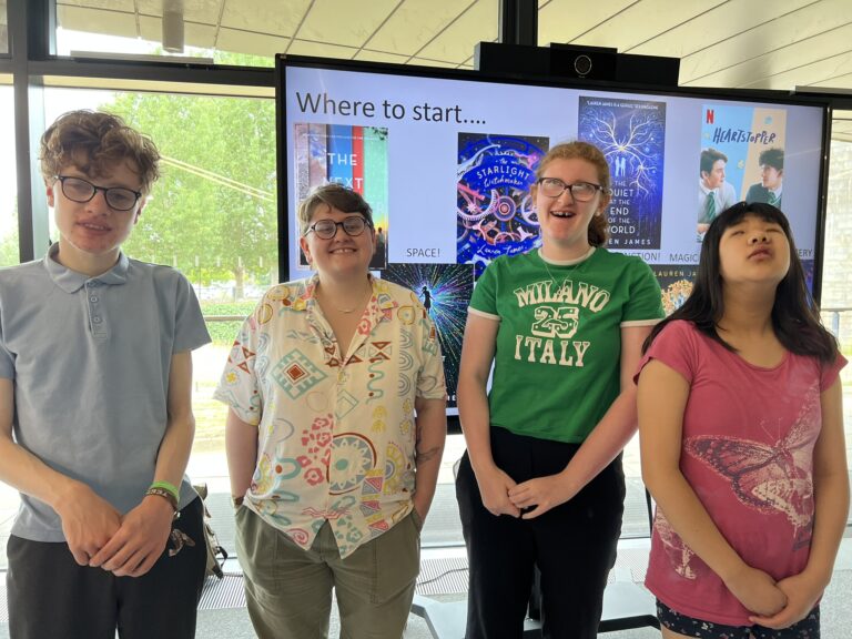 Students smiling at the camera whilst stood with Wren