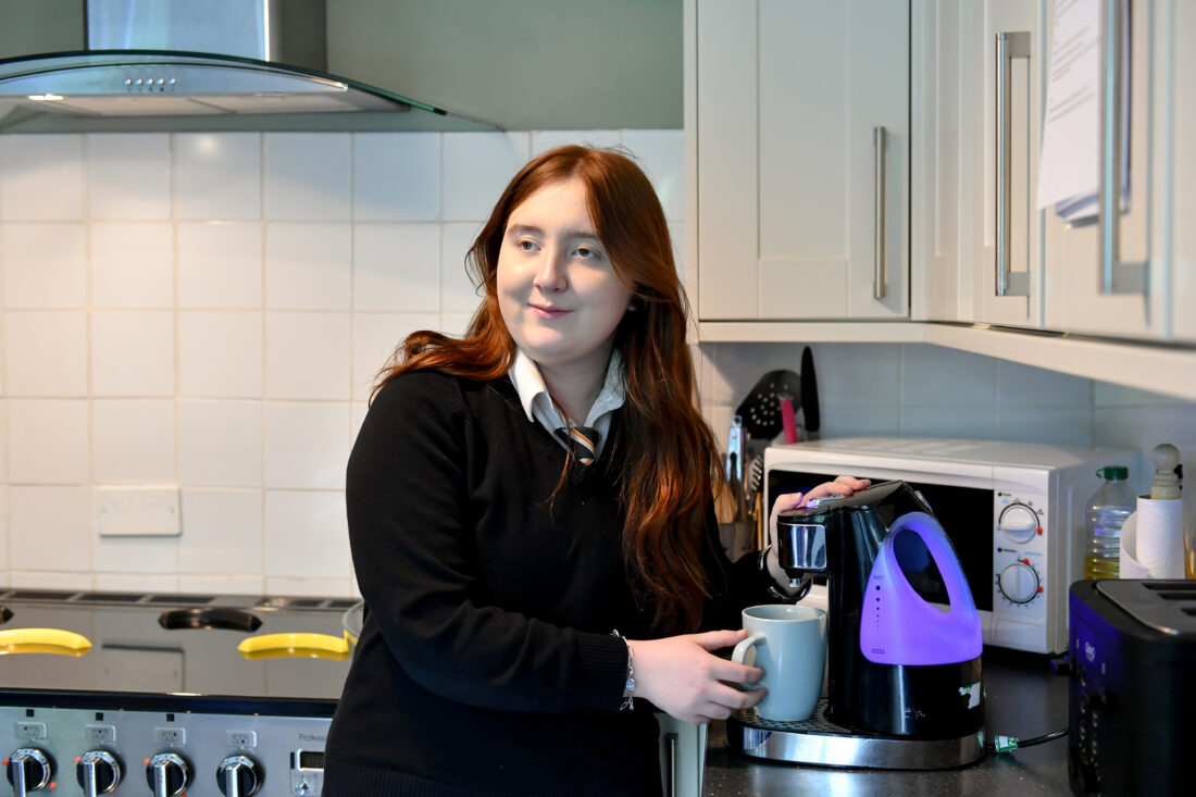 photo of a student in a kitchen using a one cup