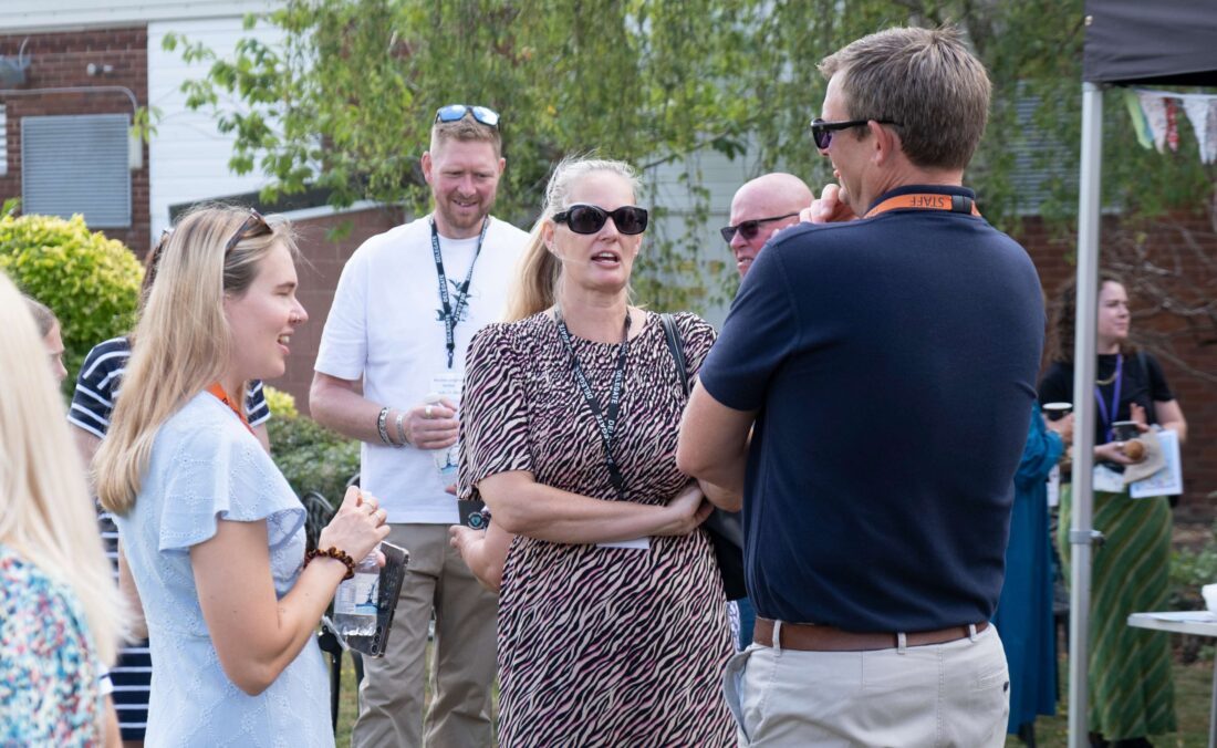 Photo of staff, students and parents mingling on the lawn