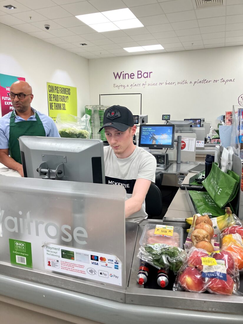 Photo of a student sat at a check out working