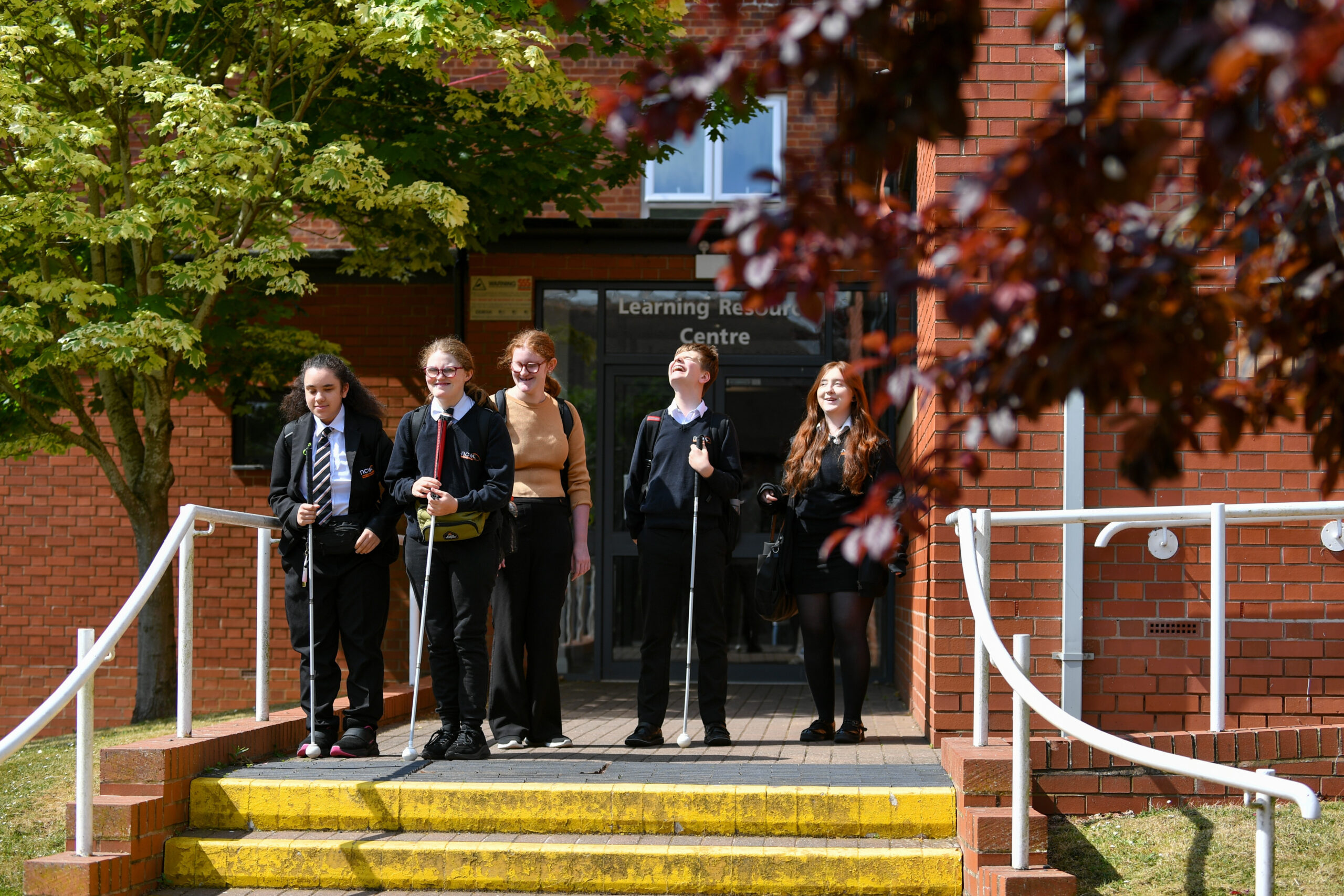 A group of six students on the steps of the LRC at NCW