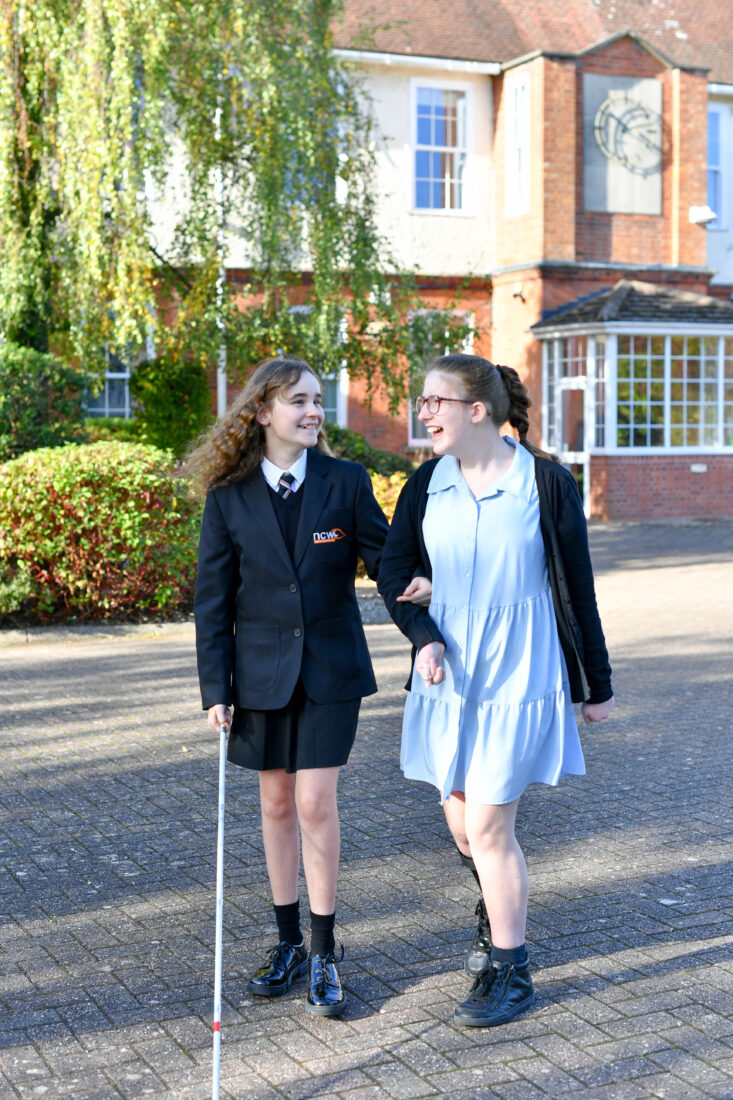 Photo of two students walking in the grounds of NCW smiling and chatting