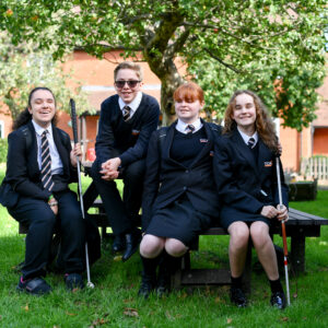 Photo of four students sat around a picnic bench chatting