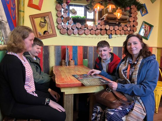 Photo of three students and Mrs Molina sat at around a table in the restaurant
