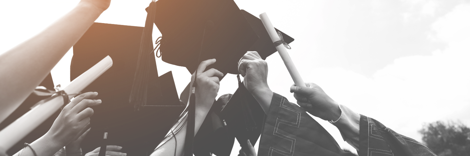 graduation hats held high in the air