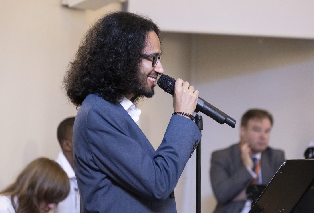 Eddy smiling and talking in to a microphone at an event at NCW