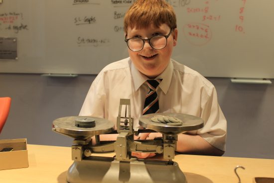 student smiling with weighing scales infront of them