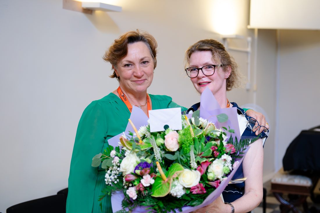 Mrs Ward and Mrs PErks smiling for a photo with Mrs Ward holding a large bunch of flowers