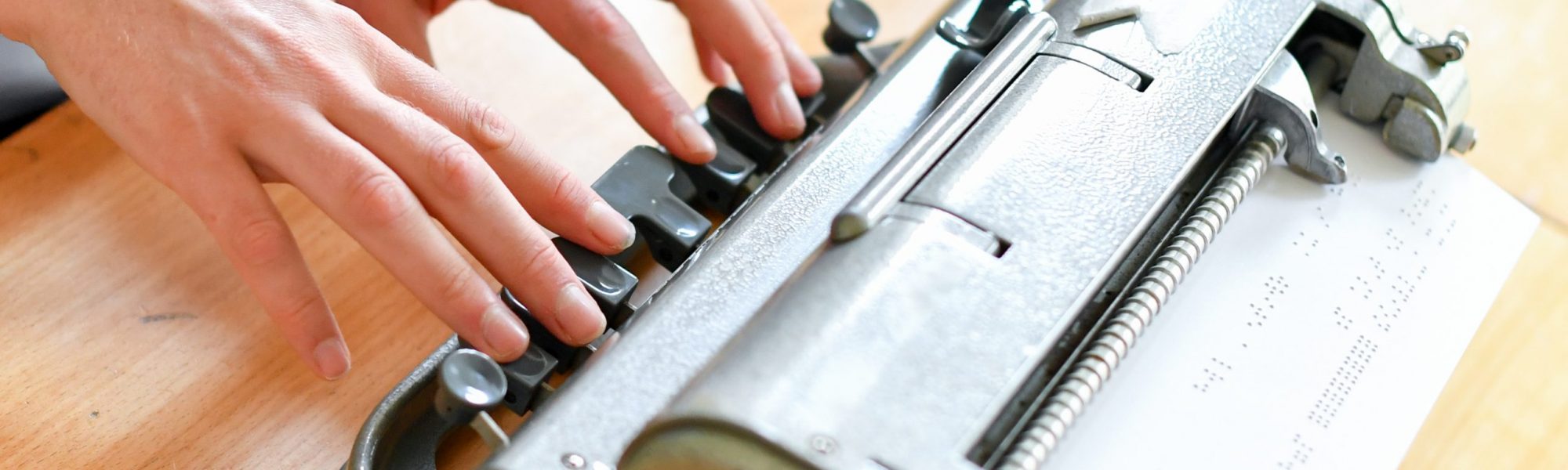 Close up of Perkins Brailler with hands